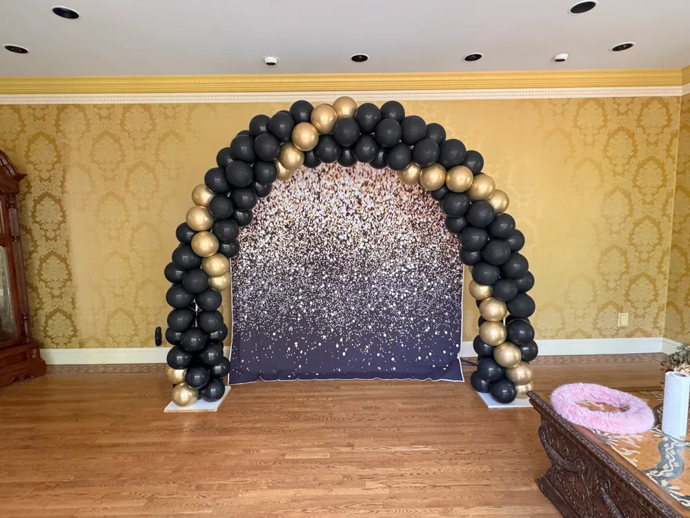 Black and gold balloon arch installation